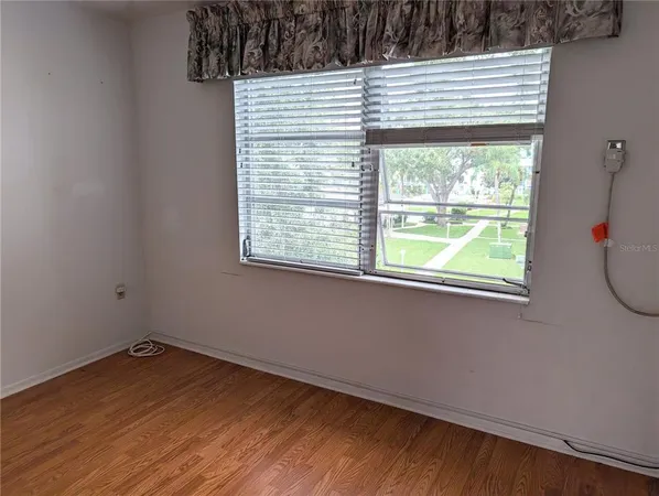 a view of a small space with wooden floor and a window