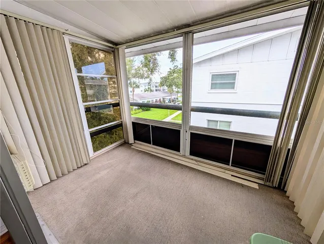a view of an empty room with a fireplace and a window