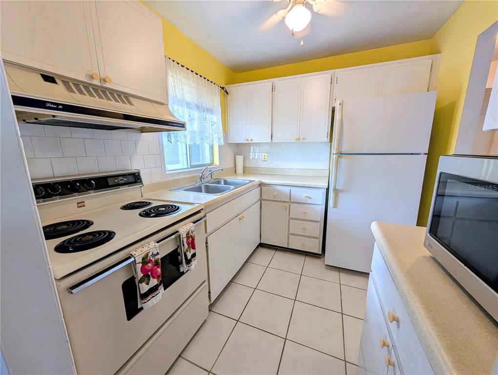 5908 17th Street West, Unit C36 Bradenton, FL 34207 - Photo 2 of 28 a kitchen with a stove a refrigerator and a sink