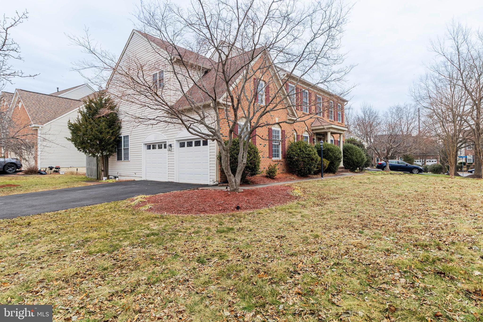 6239 Willowfield Way Springfield, VA 22150 - Photo 2 of 45 a front view of a house with a yard covered with snow and trees