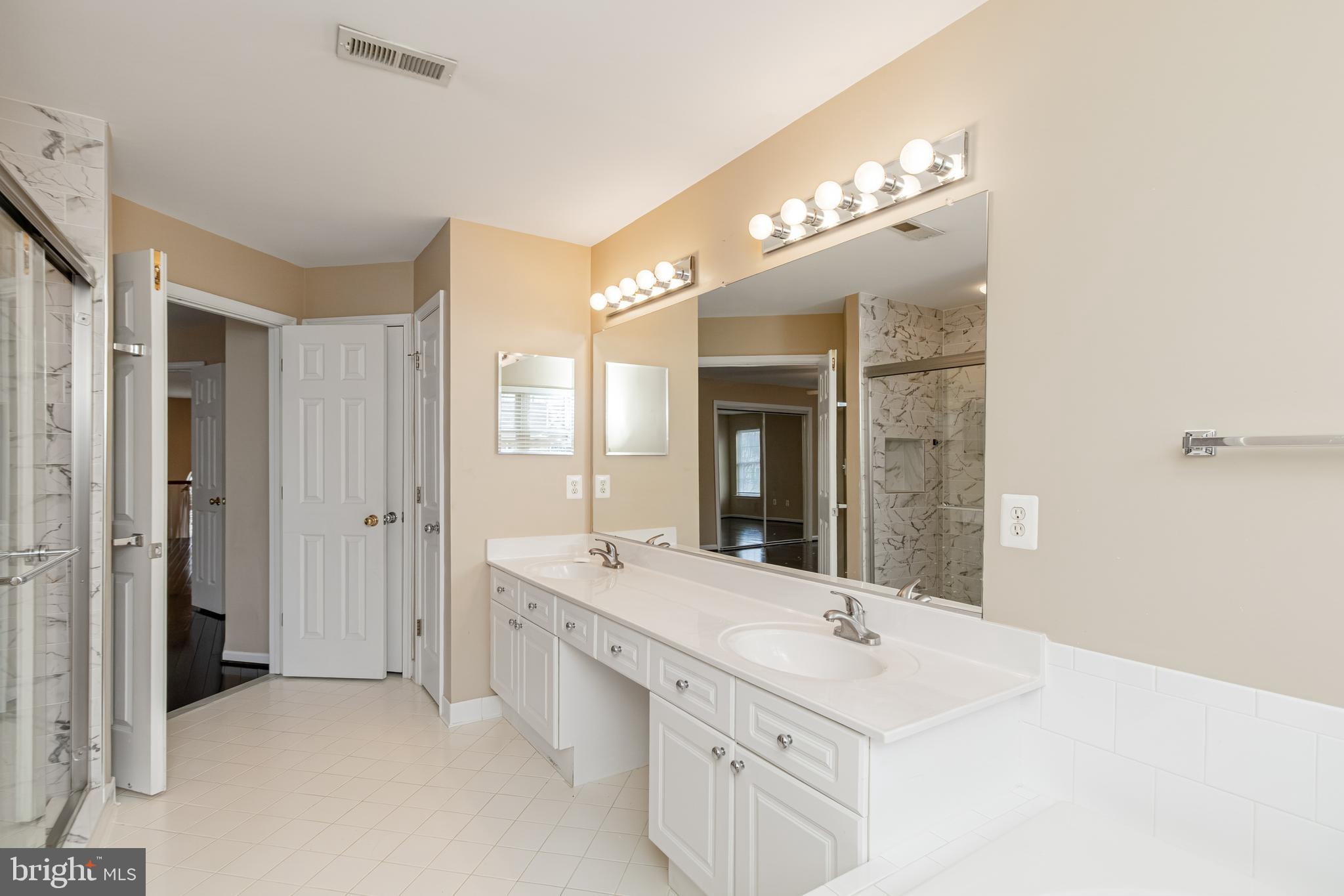 6239 Willowfield Way Springfield, VA 22150 - Photo 28 of 45 a bathroom with a sink double vanity and a mirror
