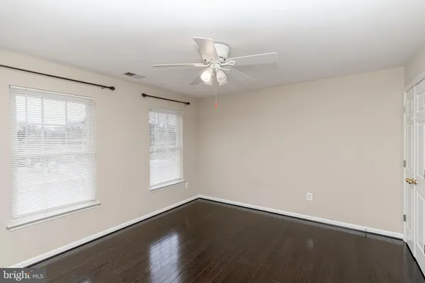 an empty room with a ceiling fan and a window