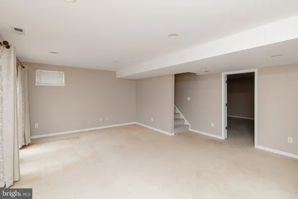 a view of an empty room with closet and a window