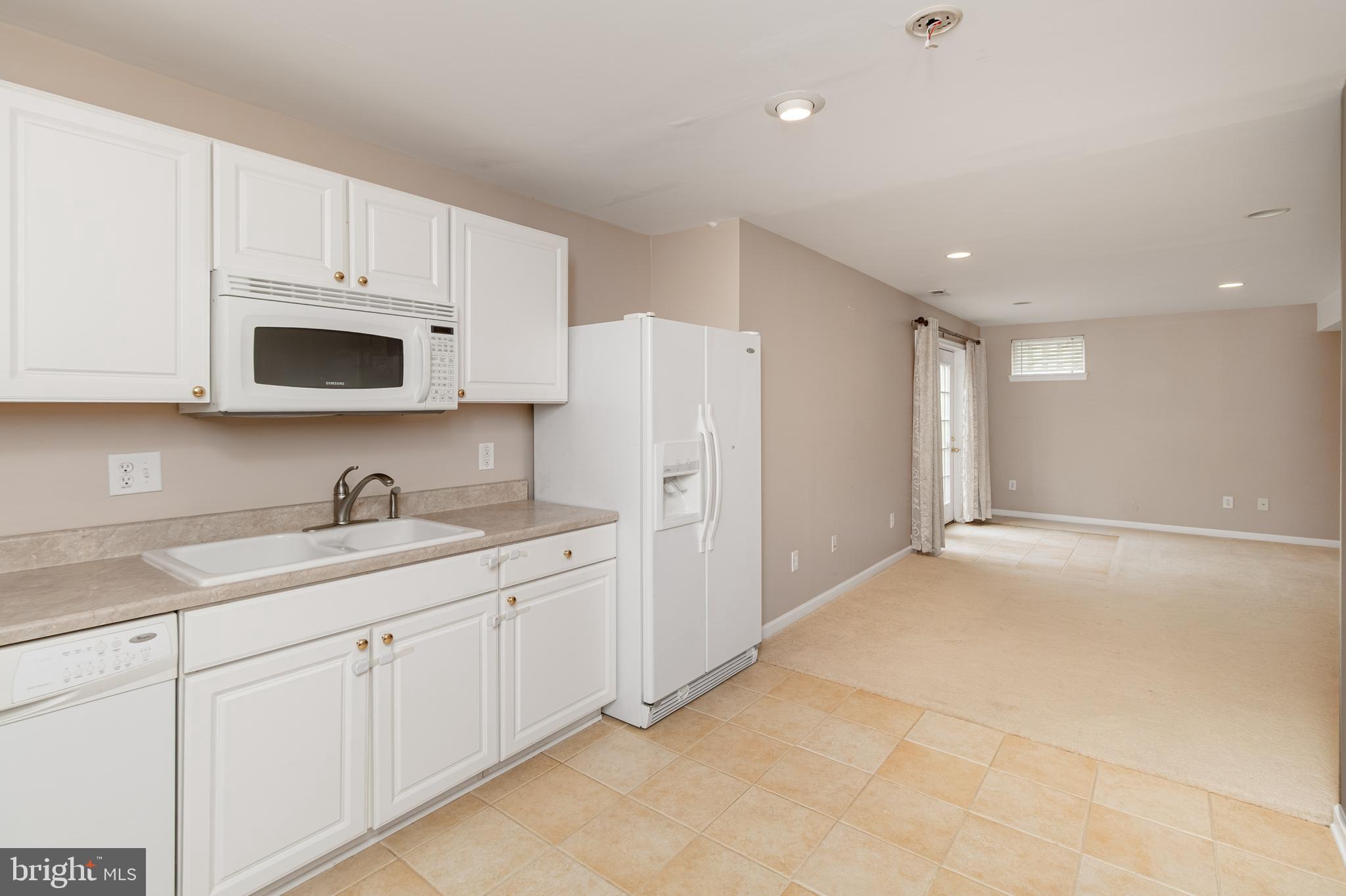6239 Willowfield Way Springfield, VA 22150 - Photo 43 of 45 a kitchen with white cabinets and white appliances