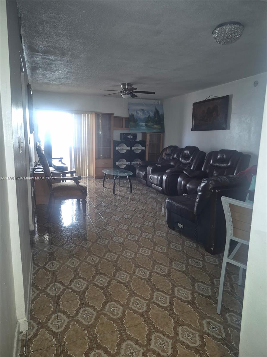 1850 West 56th Street, Unit 2410 Hialeah, FL 33012 - Photo 10 of 12 a living room with patio furniture and a chandelier
