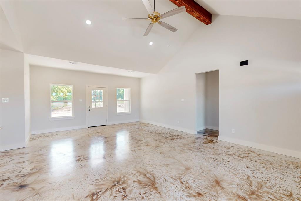 an empty room with windows and ceiling fan