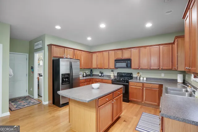 a kitchen with a sink a counter top space cabinets and stainless steel appliances