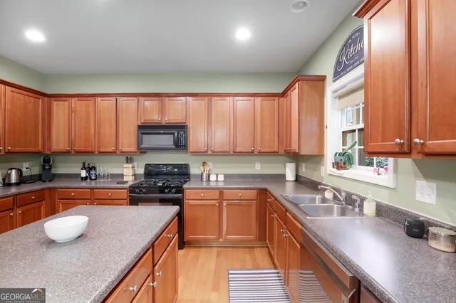 a kitchen with stainless steel appliances granite countertop a stove a sink and a microwave