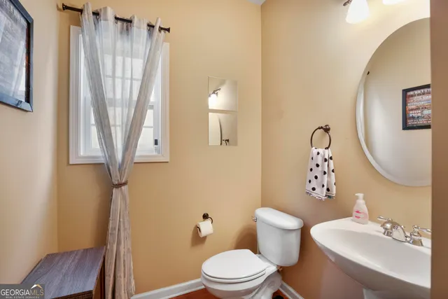 a bedroom with a bed potted plant on table and windows