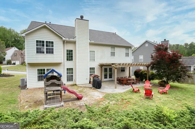 a front view of house with yard and trees in the background