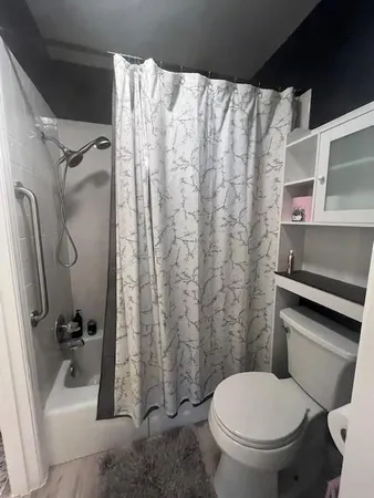 a white toilet sitting next to a bath tub