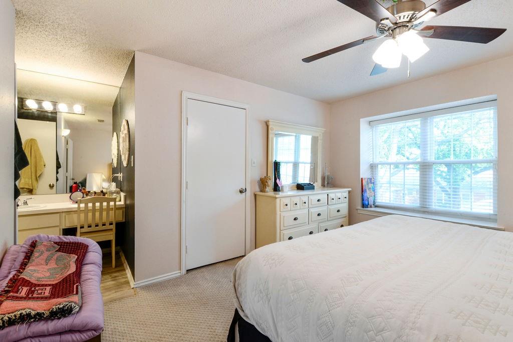 933 Roaring Springs Road Fort Worth, TX 76114 - Photo 18 of 25 a bedroom with a bed and a chandelier