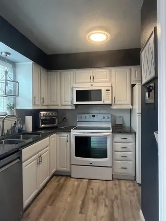 a kitchen with cabinets stainless steel appliances and a counter space