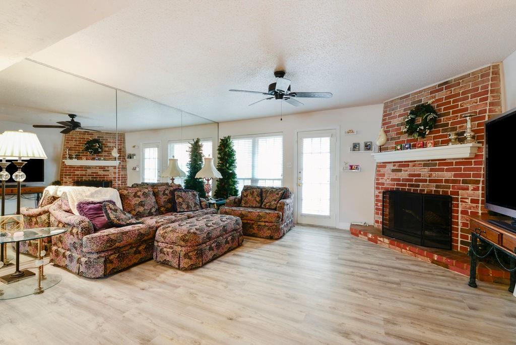 933 Roaring Springs Road Fort Worth, TX 76114 - Photo 8 of 25 a living room with furniture a fireplace and a flat screen tv