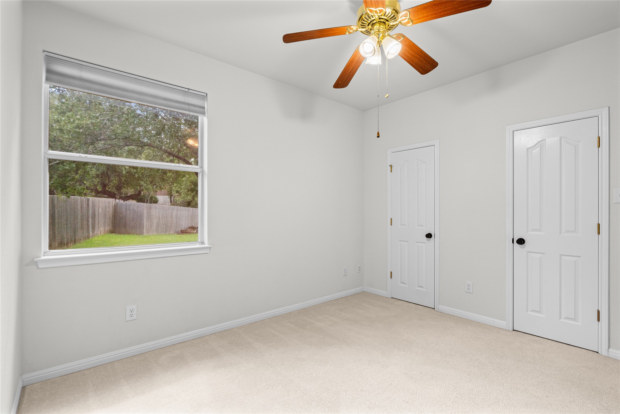 10700 Pointe View Drive Austin, TX 78738 - Photo 14 of 35 A well-lit bedroom offering comfort and a direct view of the backyard's natural surroundings.