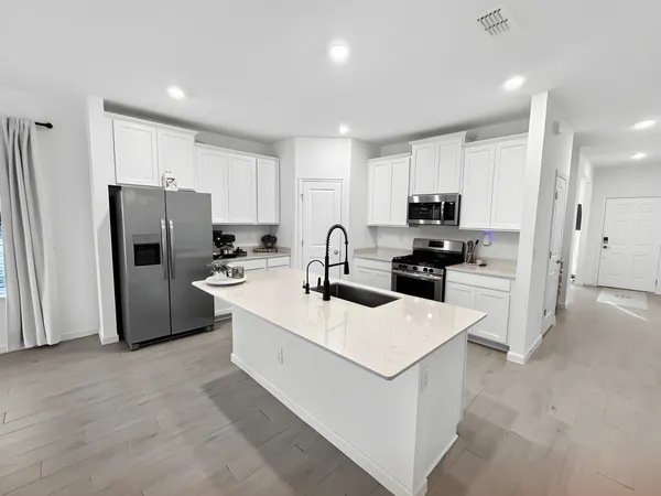 a kitchen with refrigerator a sink and cabinets