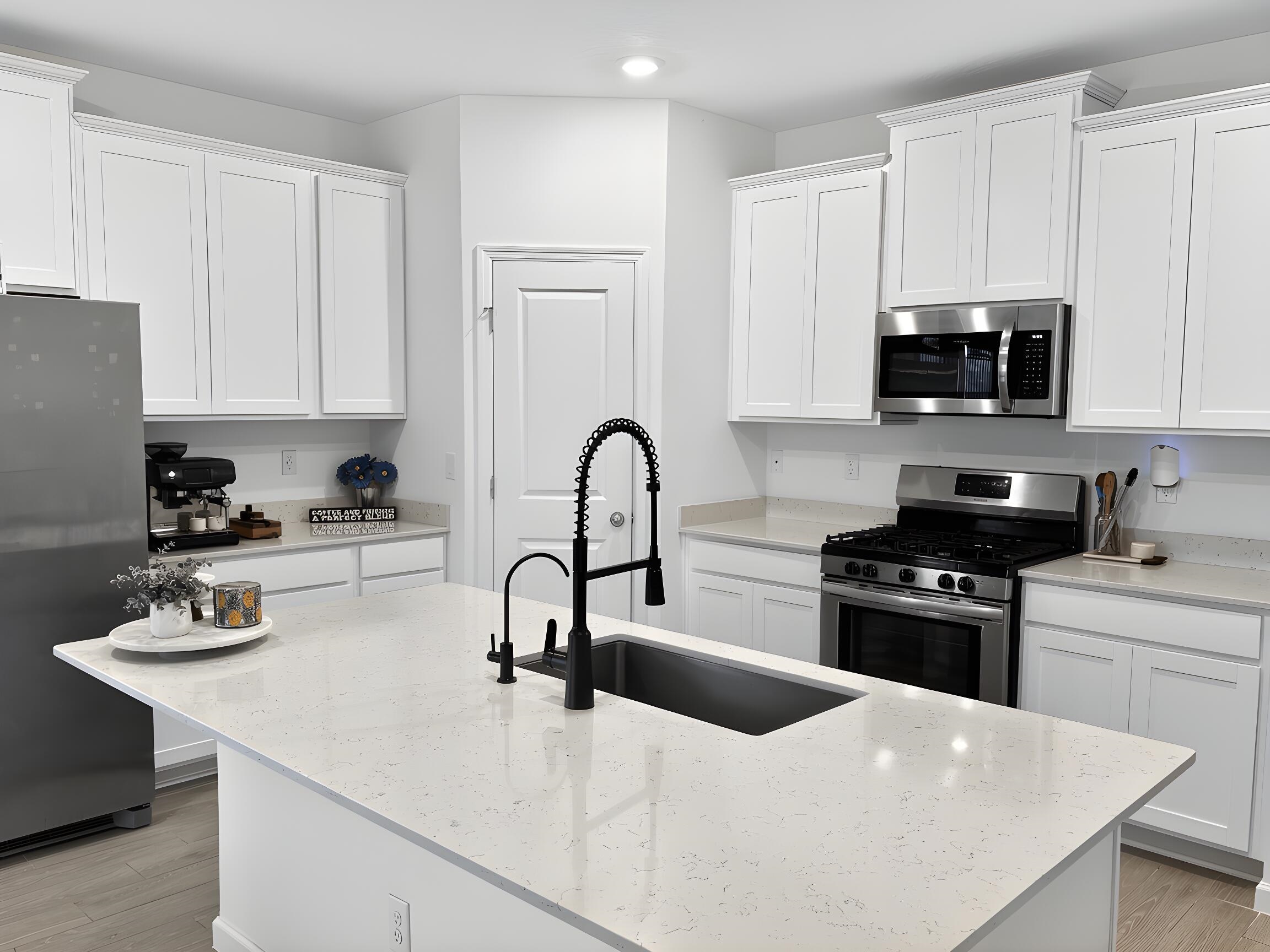 63 Quicksilver Way St. Augustine, FL 32092 - Photo 12 of 36 Kitchen featuring stainless steel appliances, white cabinets, light wood-type flooring, light stone countertops, and a kitchen island with sink