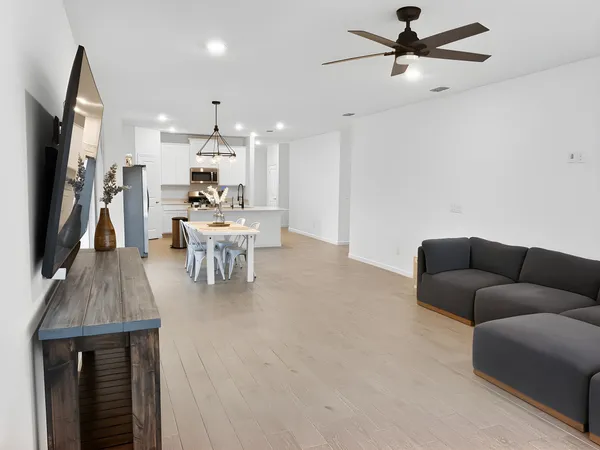 a kitchen with stainless steel appliances kitchen island granite countertop a table chairs and a refrigerator