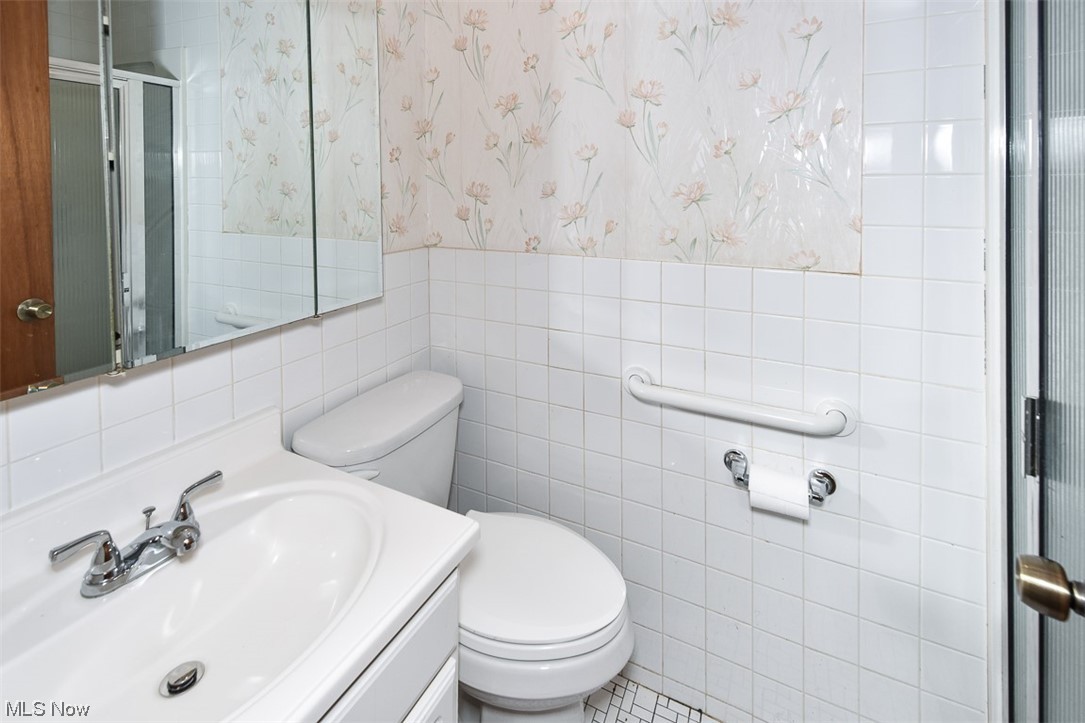 4026 Stonehaven Road Cleveland, OH 44121 - Photo 11 of 30 Bathroom with toilet, tile walls, and vanity