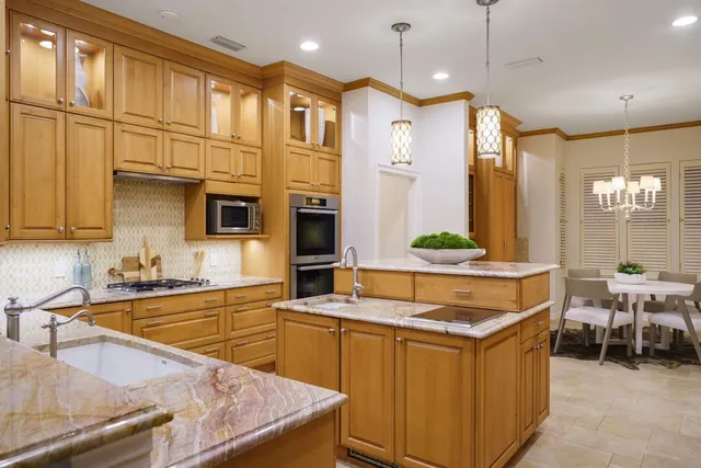 a kitchen with stainless steel appliances granite countertop a sink a stove and a refrigerator