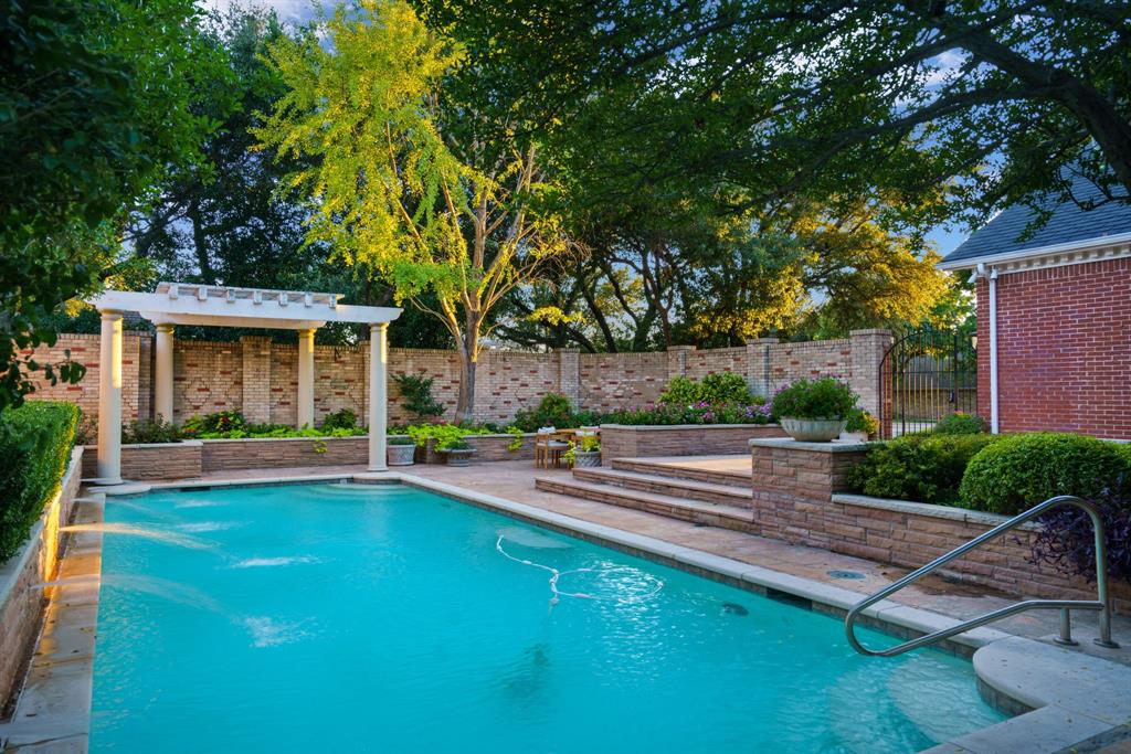 7104 Judi Court Dallas, TX 75252 - Photo 5 of 40 a view of a house with pool fire pit a table and chairs next to a yard