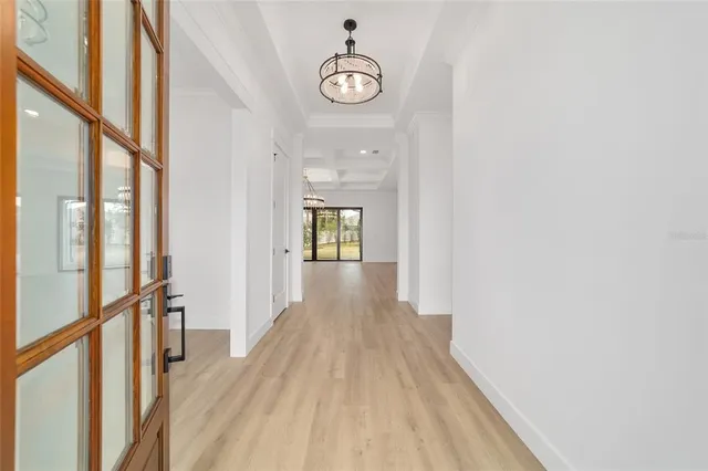 a view of an empty room with glass door and windows