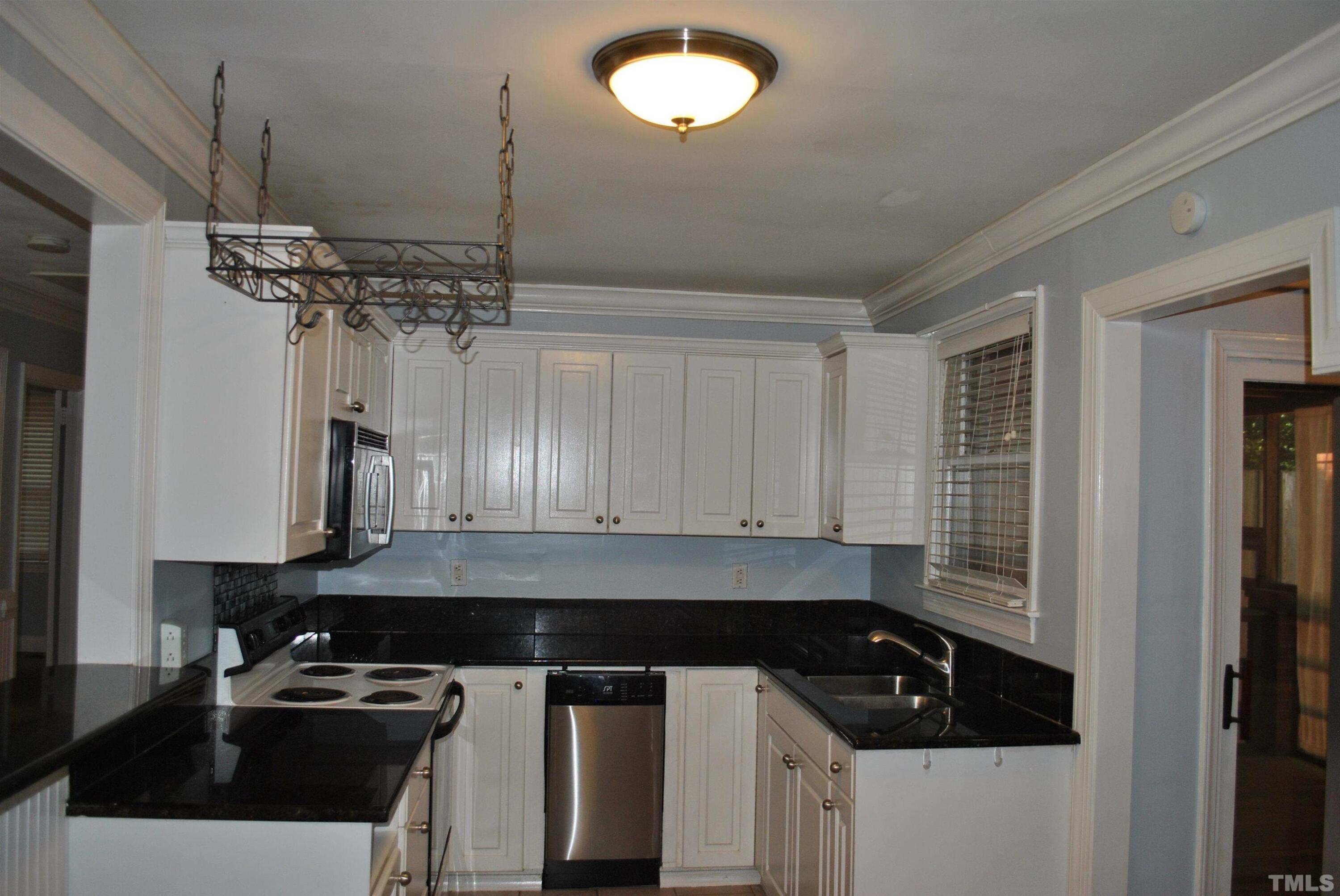 2106 Brewer Street Raleigh, NC 27608 - Photo 14 of 38 a kitchen with a sink a stove and cabinets