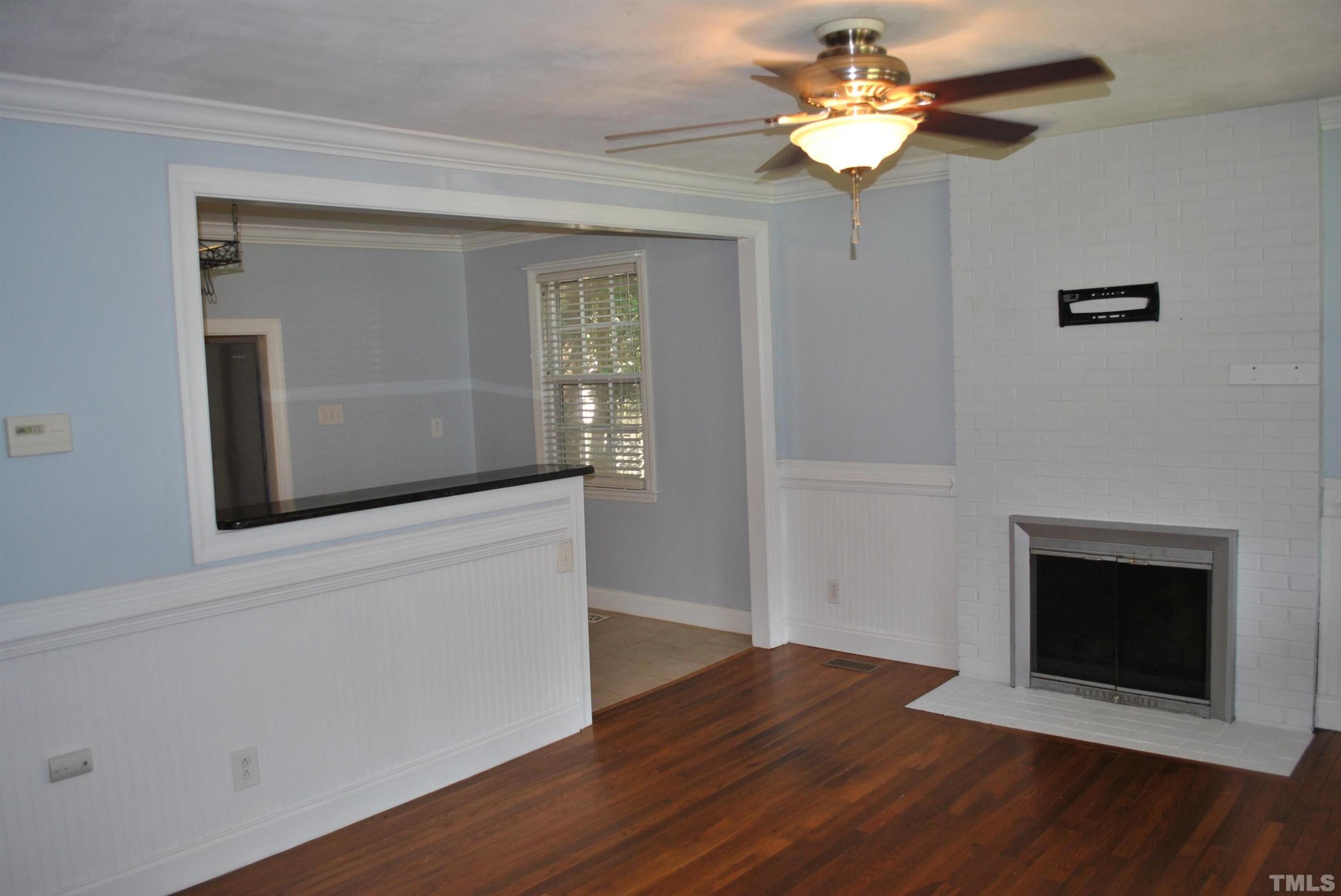 2106 Brewer Street Raleigh, NC 27608 - Photo 15 of 38 a view of an empty room with wooden floor and a fireplace