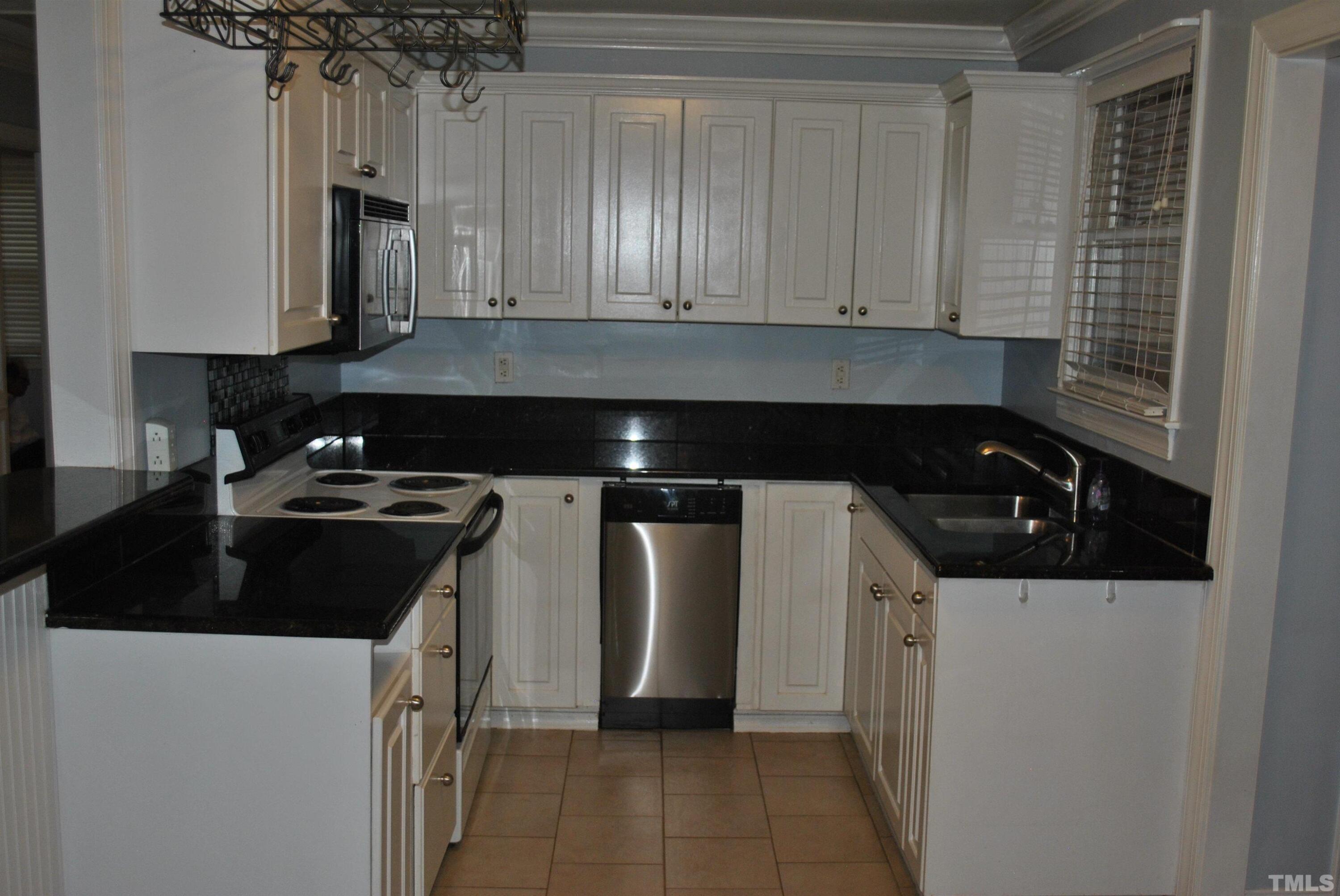 2106 Brewer Street Raleigh, NC 27608 - Photo 17 of 38 a kitchen with a sink and a stove