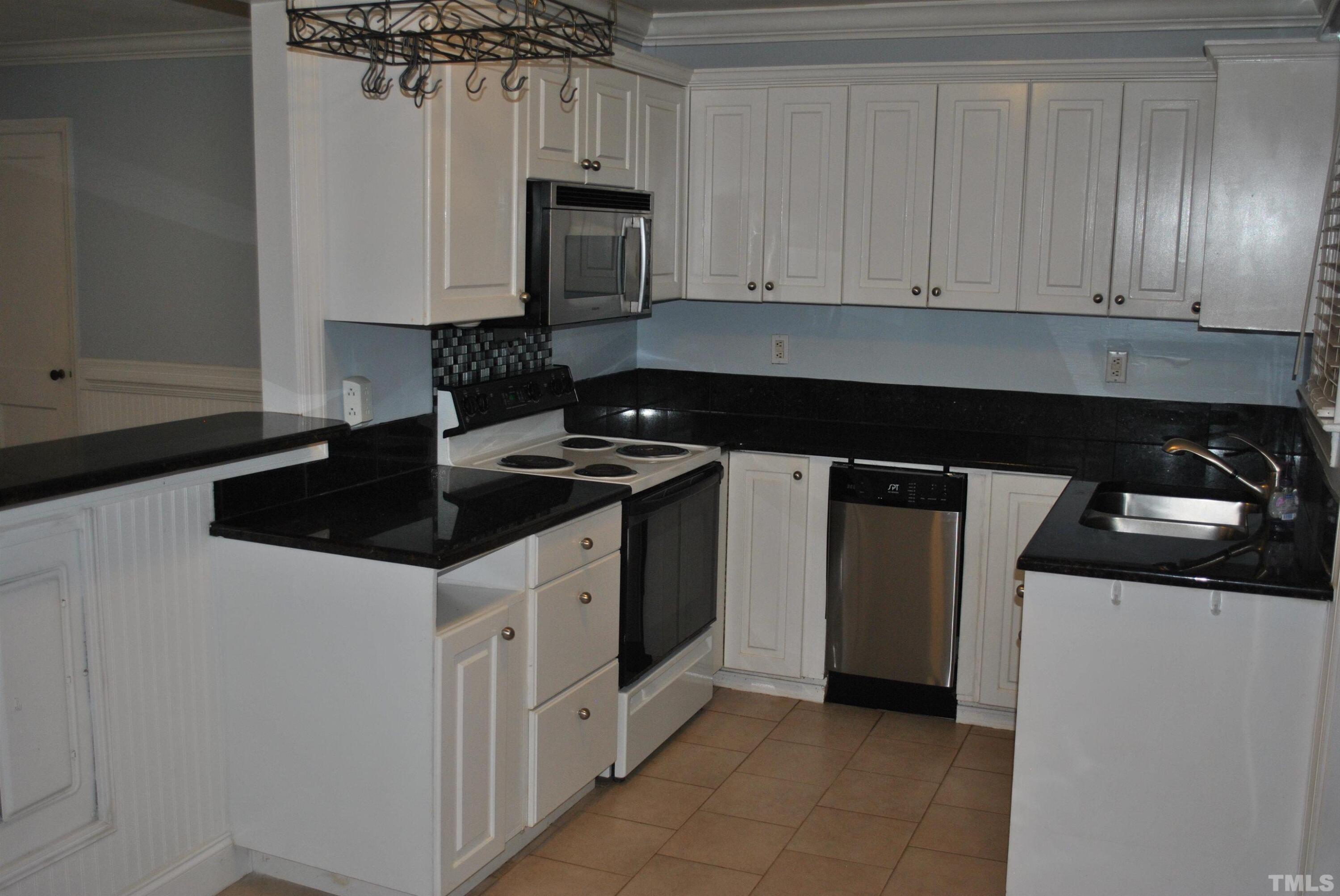 2106 Brewer Street Raleigh, NC 27608 - Photo 18 of 38 a kitchen with a sink and cabinets