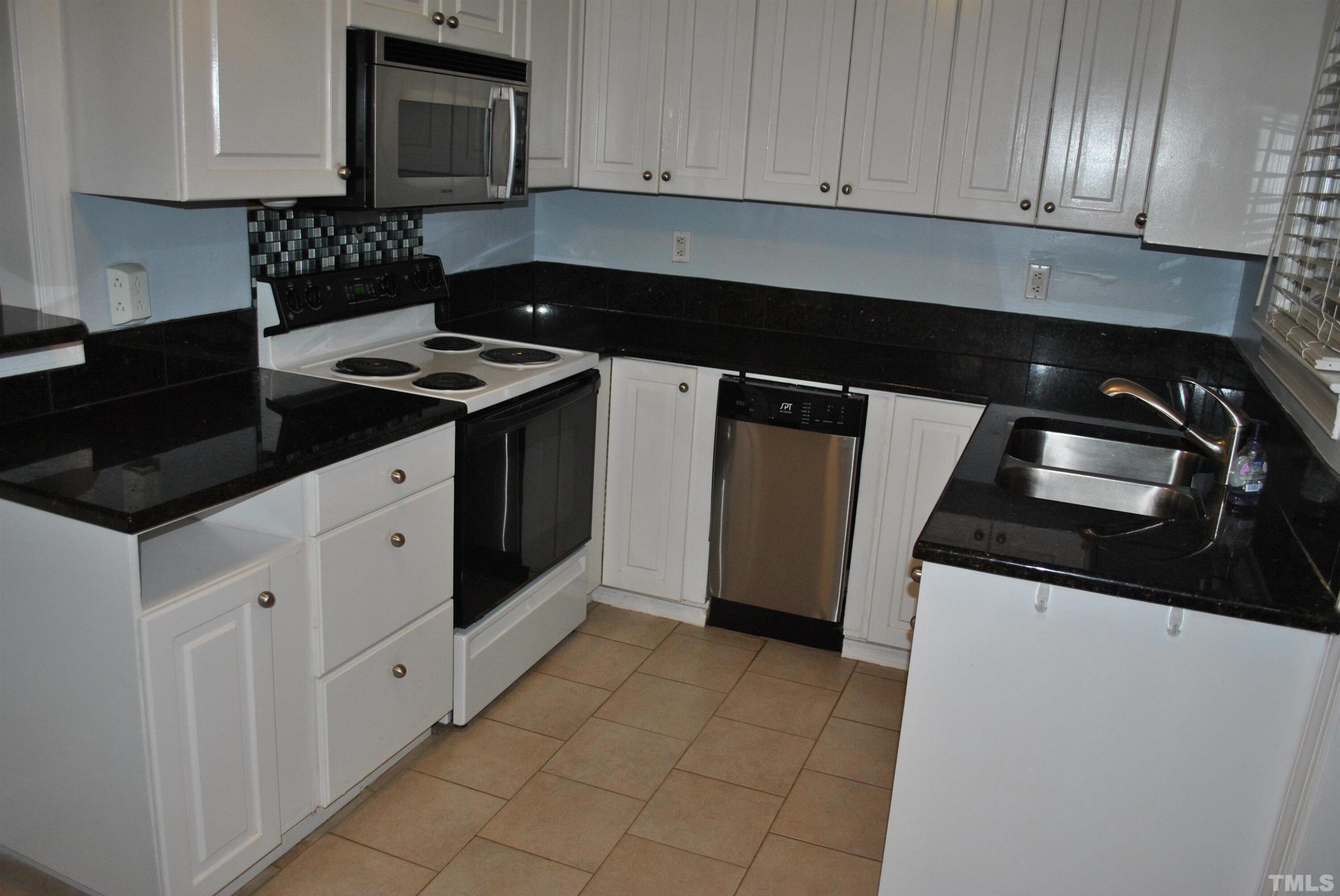 2106 Brewer Street Raleigh, NC 27608 - Photo 19 of 38 a kitchen with granite countertop white cabinets and stainless steel appliances