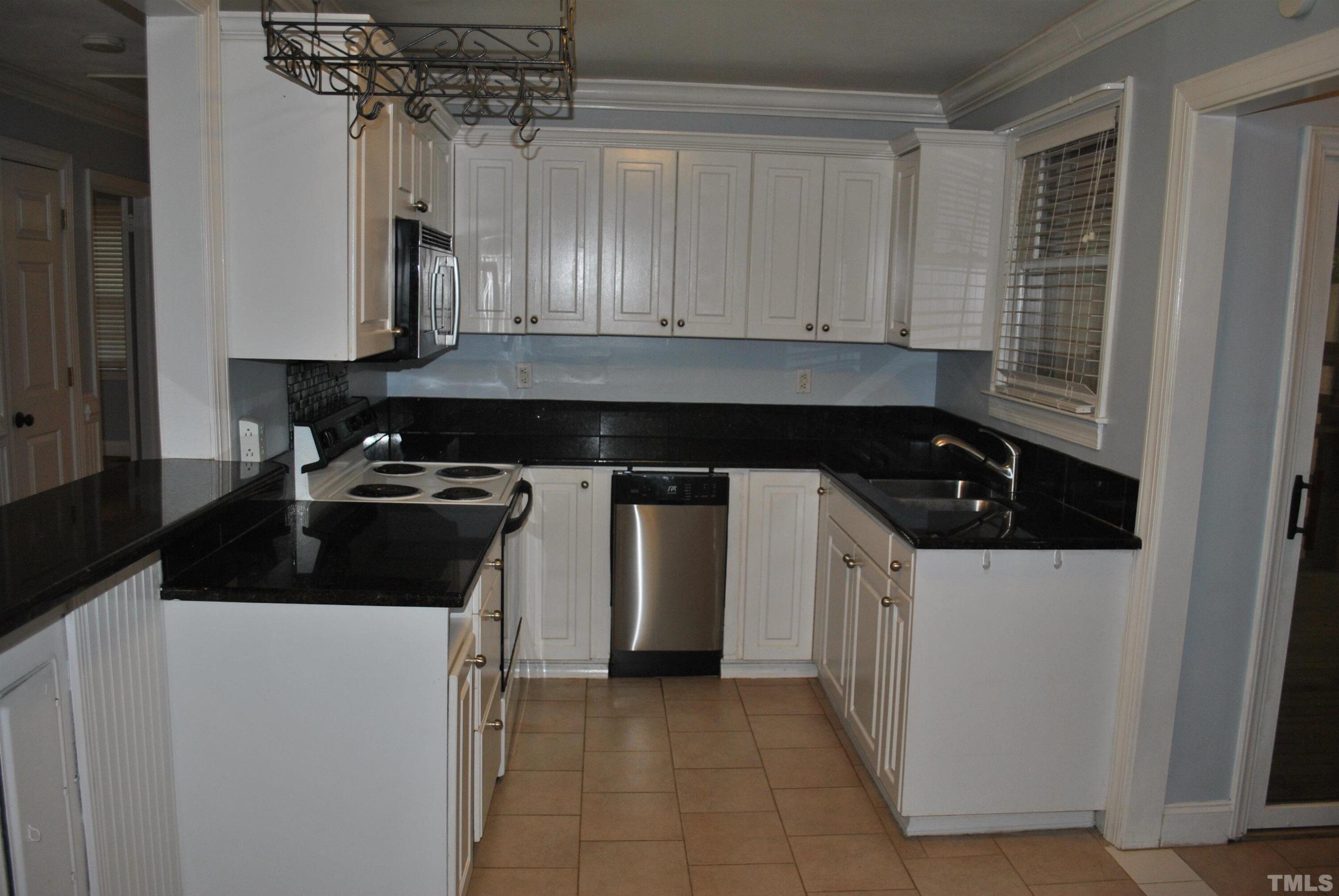 2106 Brewer Street Raleigh, NC 27608 - Photo 22 of 38 a kitchen with a sink stove and cabinets