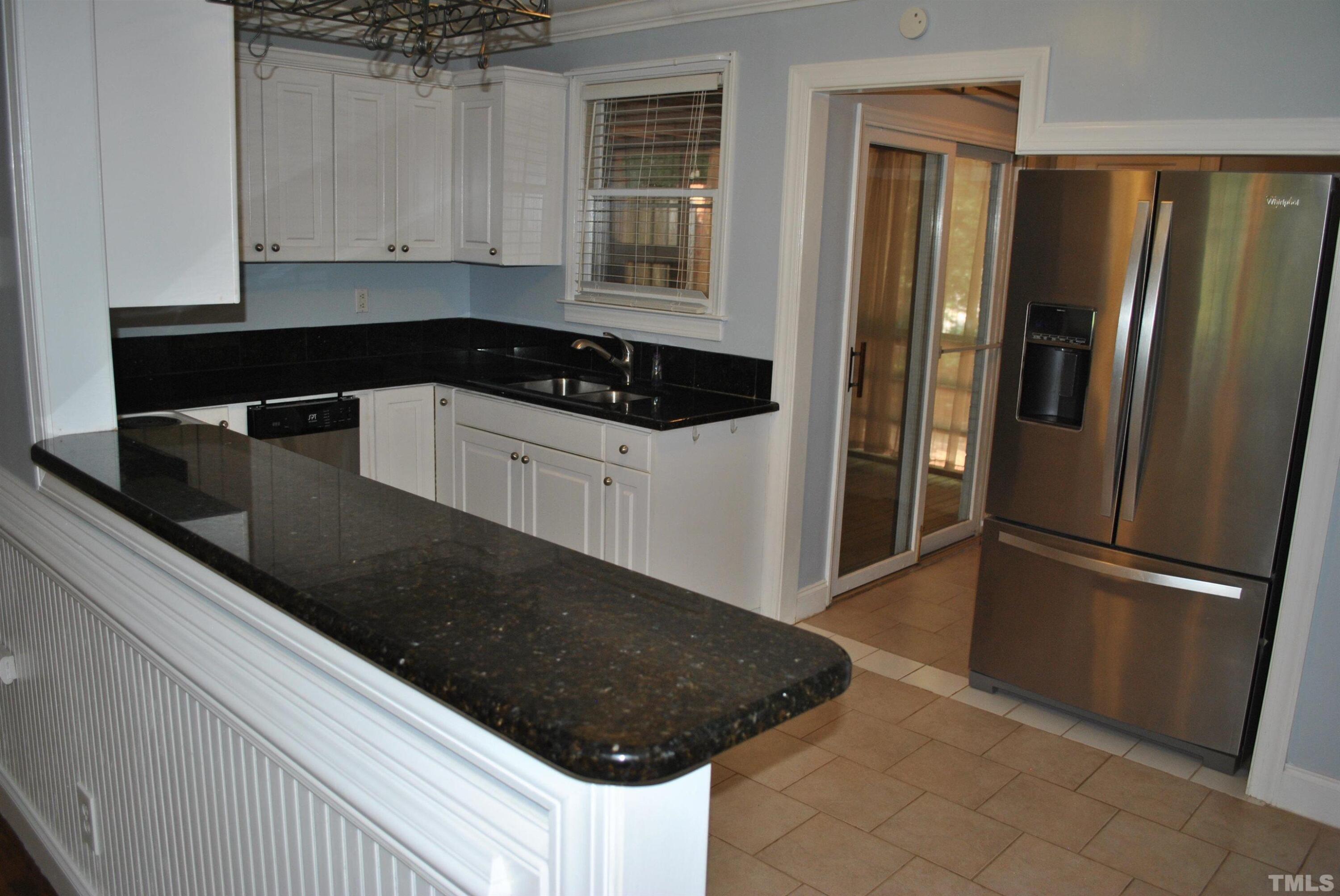 2106 Brewer Street Raleigh, NC 27608 - Photo 24 of 38 a kitchen with a refrigerator and cabinets