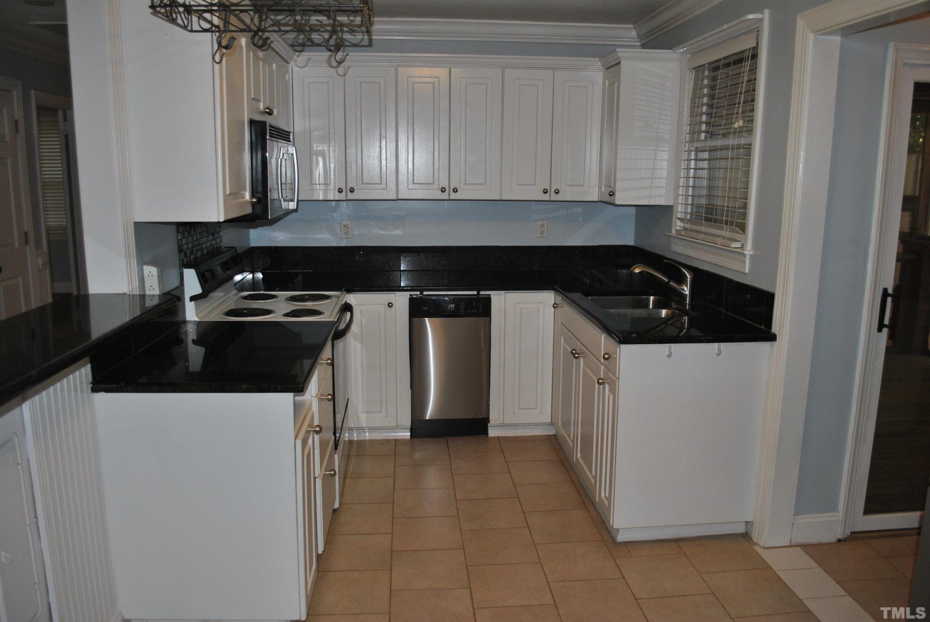 2106 Brewer Street Raleigh, NC 27608 - Photo 28 of 38 a kitchen with a sink and cabinets