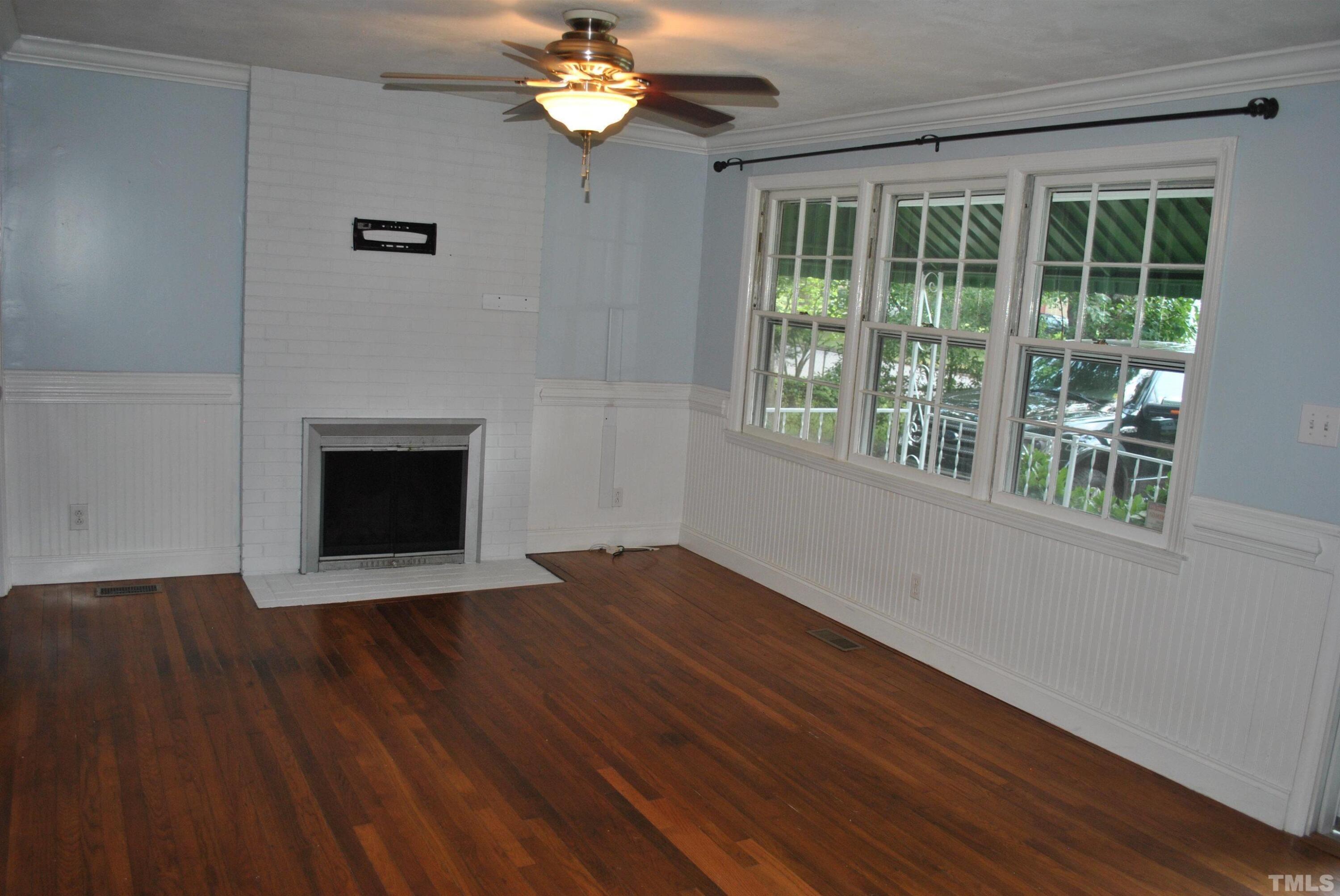 2106 Brewer Street Raleigh, NC 27608 - Photo 3 of 38 a view of an empty room with wooden floor and a window