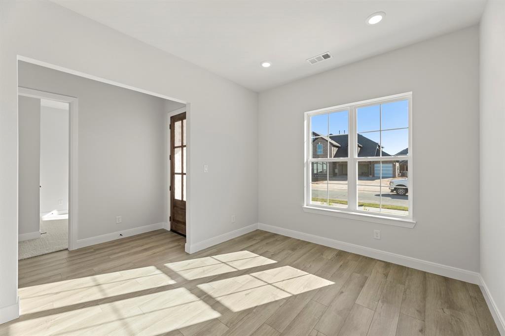 912 Firewood Way Anna, TX 75409 - Photo 4 of 29 an empty room with wooden floor and windows