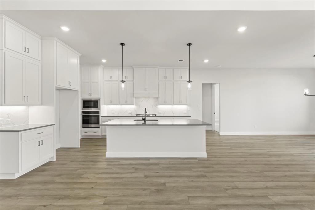912 Firewood Way Anna, TX 75409 - Photo 9 of 29 a kitchen with stainless steel appliances granite countertop a white stove top oven and white cabinets