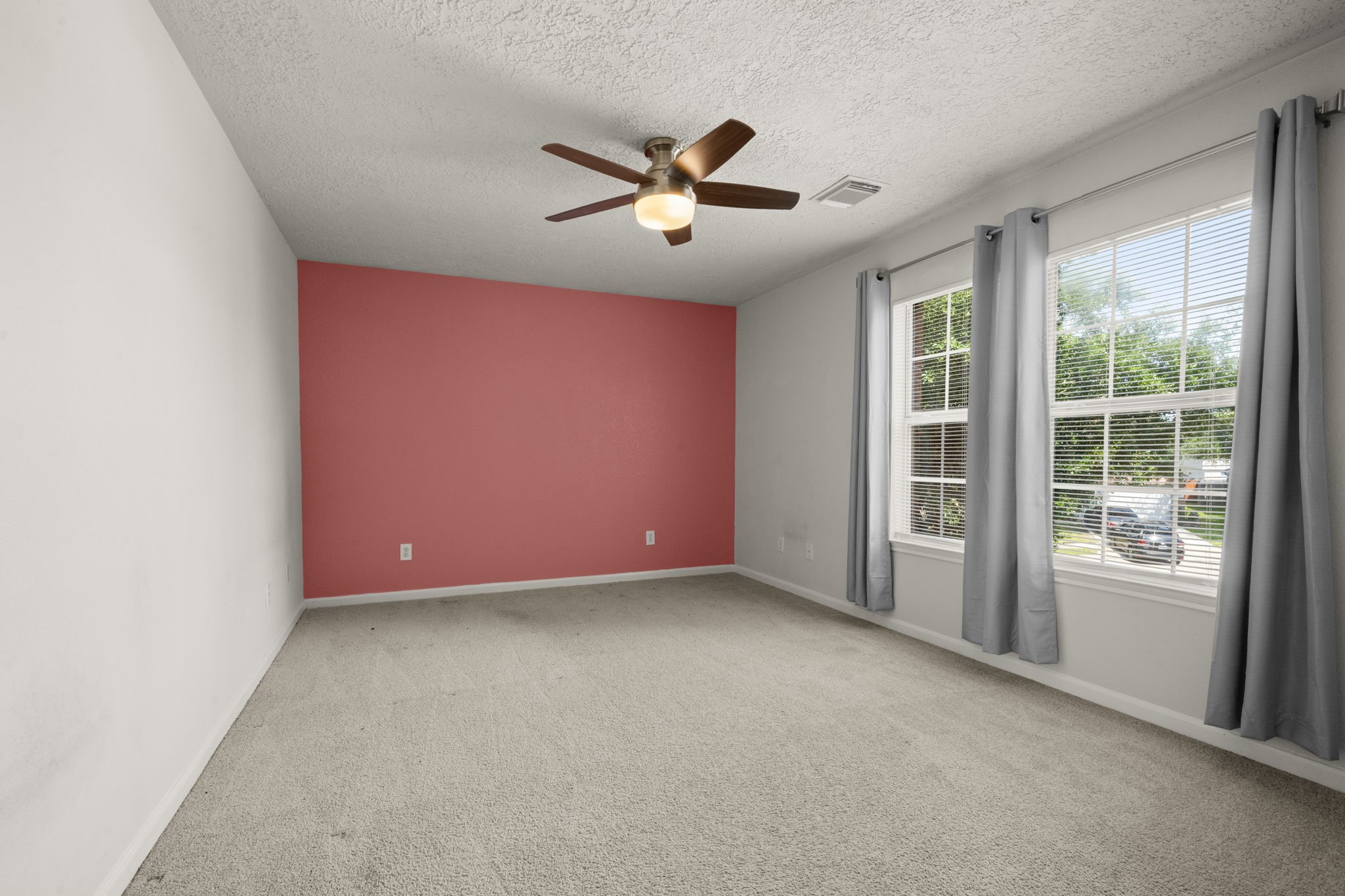 19819 Rippling Brook Lane Tomball, TX 77375 - Photo 22 of 28 Bedroom 2 - Neutral carpet, ceiling fan, accent wall and double windows.