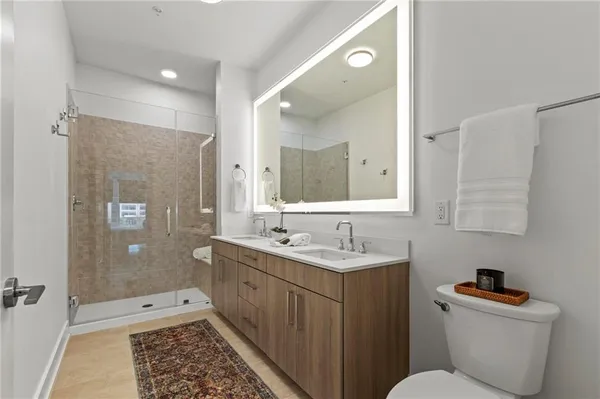 a bathroom with a double vanity sink toilet and shower