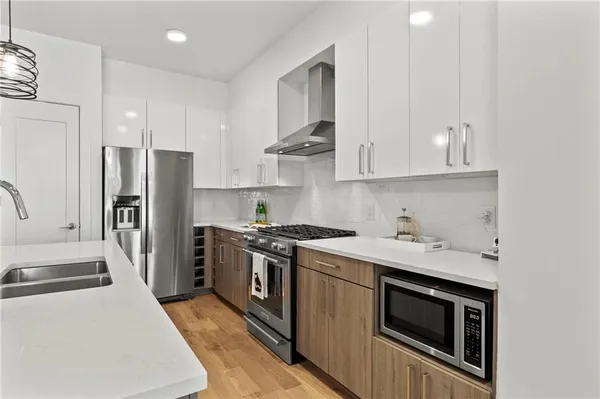 a kitchen with stainless steel appliances a stove a sink and a refrigerator