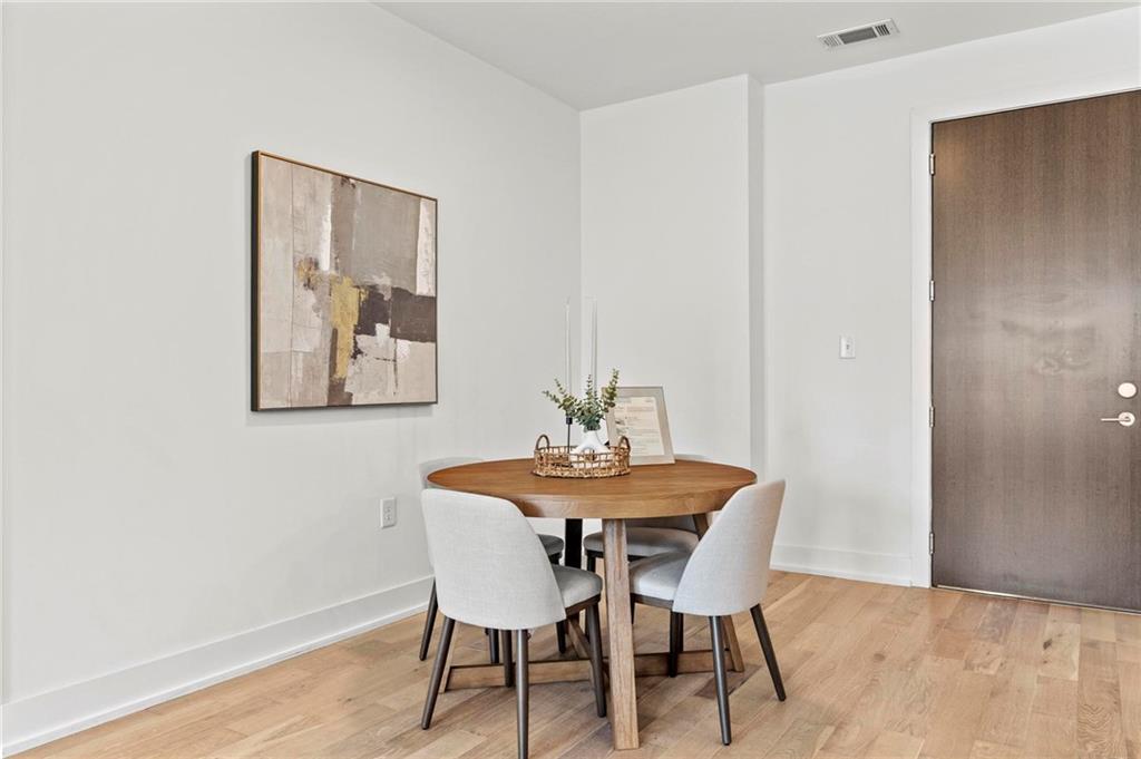 775 Juniper Street Northeast, Unit 613 Atlanta, GA 30308 - Photo 9 of 39 a view of a dining room with furniture and wooden floor