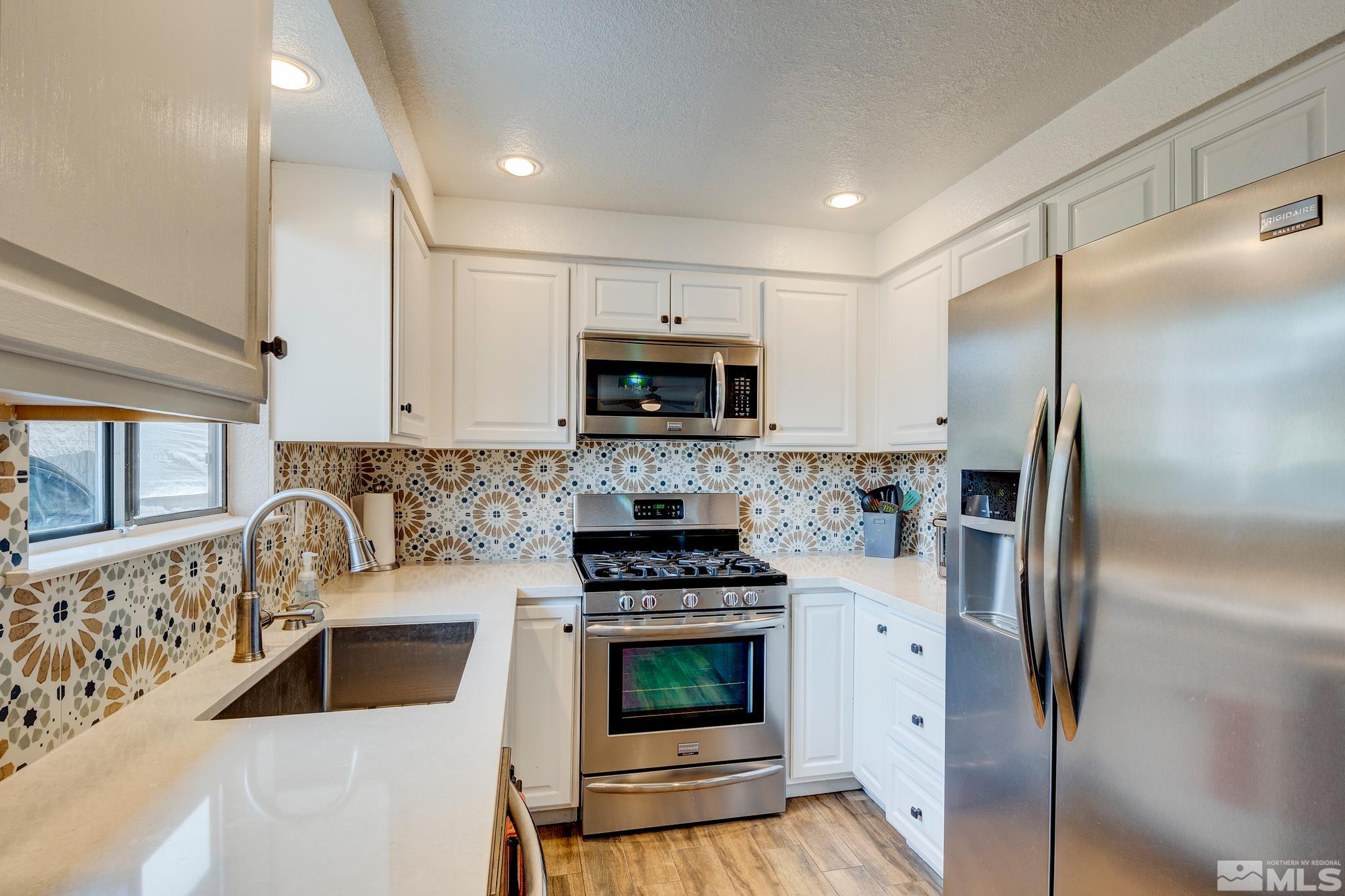 1000 Roberts Street Reno, NV 89502 - Photo 3 of 40 a kitchen with white cabinets and a stove top oven