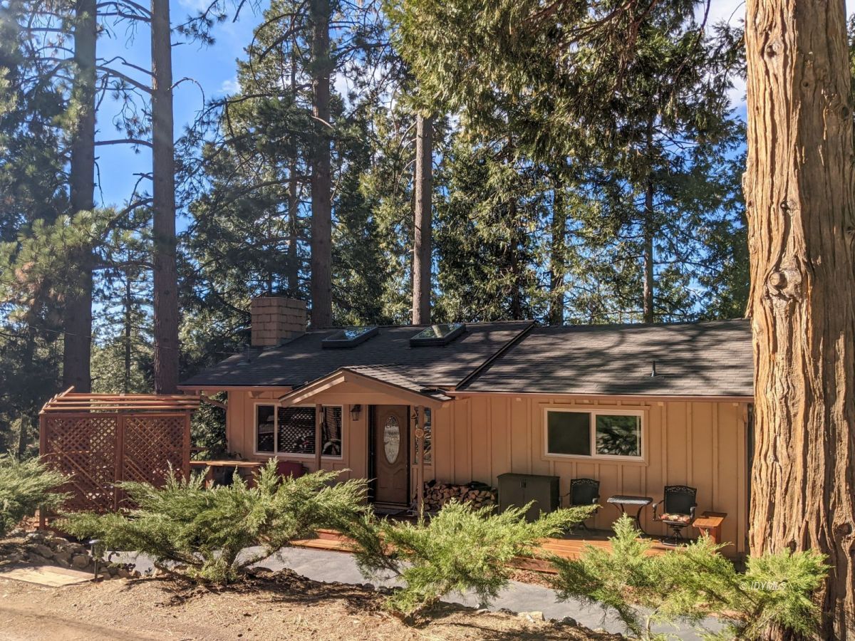 a front view of house with yard and trees around