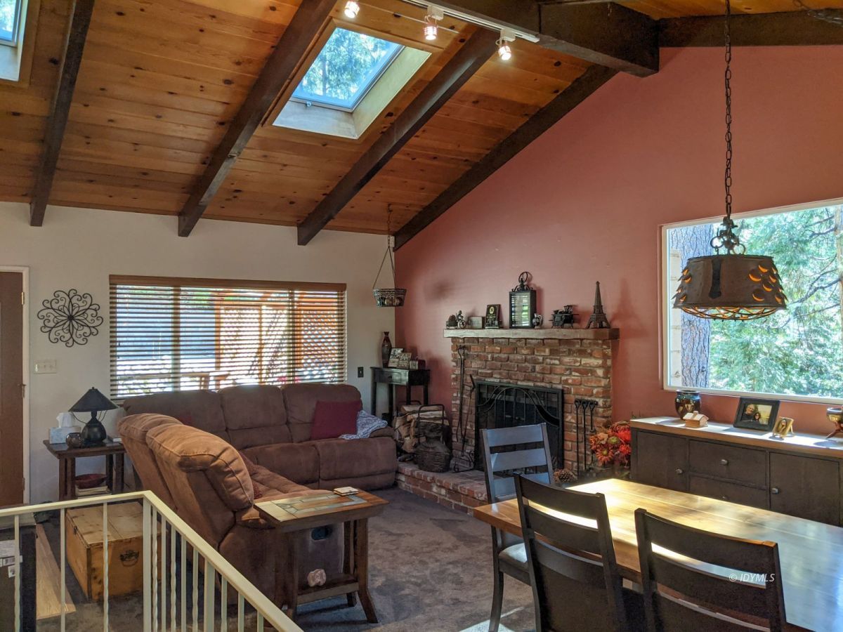 25915 Wayne Road Idyllwild, CA 92549 - Photo 12 of 69 a living room with furniture a fireplace and a floor to ceiling window