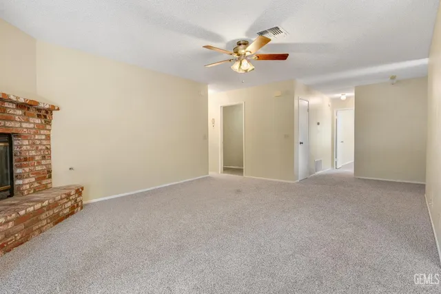 a view of an empty room with a chandelier fan