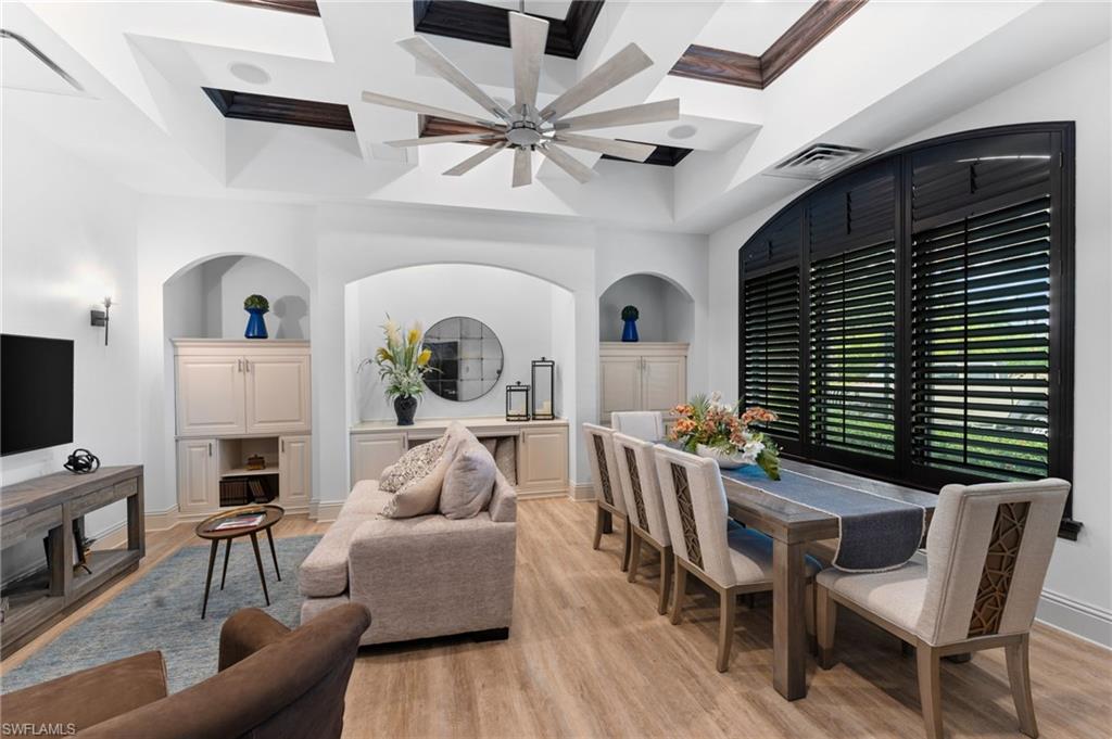 12920 Positano Circle, Unit 303 Naples, FL 34105 - Photo 16 of 21 a living room with furniture a fireplace and a flat screen tv