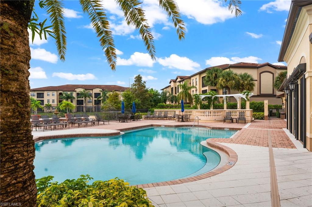 12920 Positano Circle, Unit 303 Naples, FL 34105 - Photo 18 of 21 a view of a swimming pool with outdoor seating and plants
