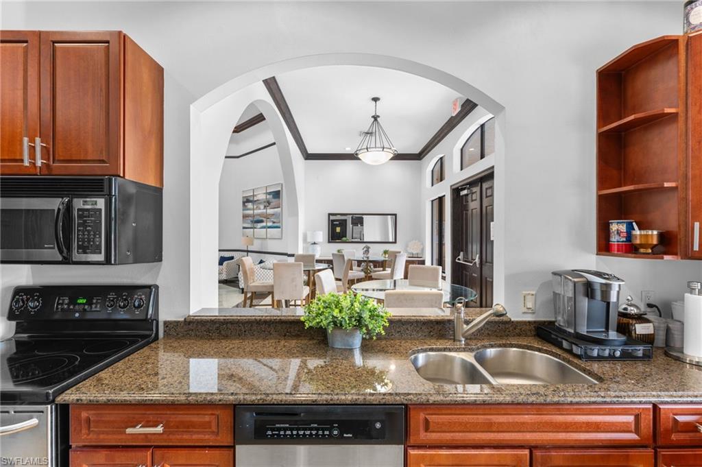 12920 Positano Circle, Unit 303 Naples, FL 34105 - Photo 4 of 21 a kitchen with stainless steel appliances granite countertop a sink and cabinets