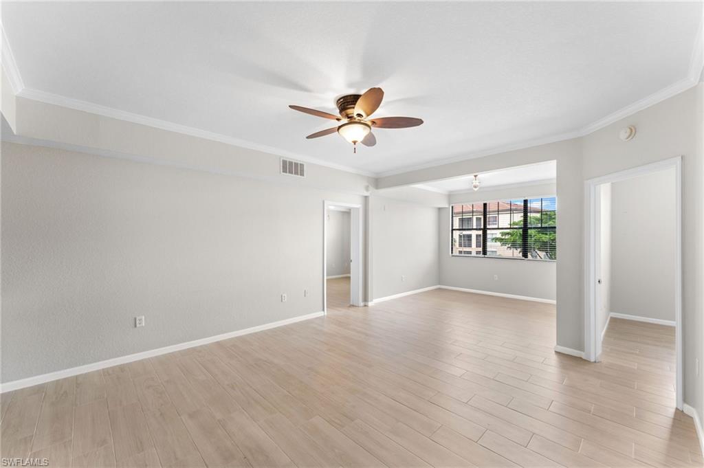 12920 Positano Circle, Unit 303 Naples, FL 34105 - Photo 5 of 21 wooden floor in an empty room with a window