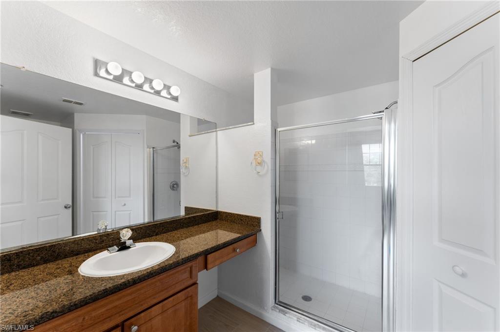 12920 Positano Circle, Unit 303 Naples, FL 34105 - Photo 6 of 21 a bathroom with a sink and a mirror